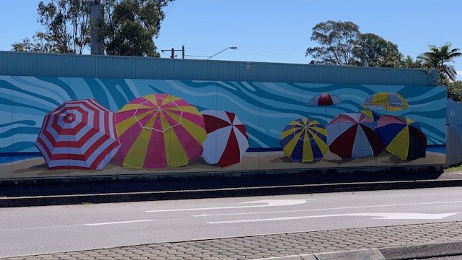 Construction hoarding with beach umbrella mural