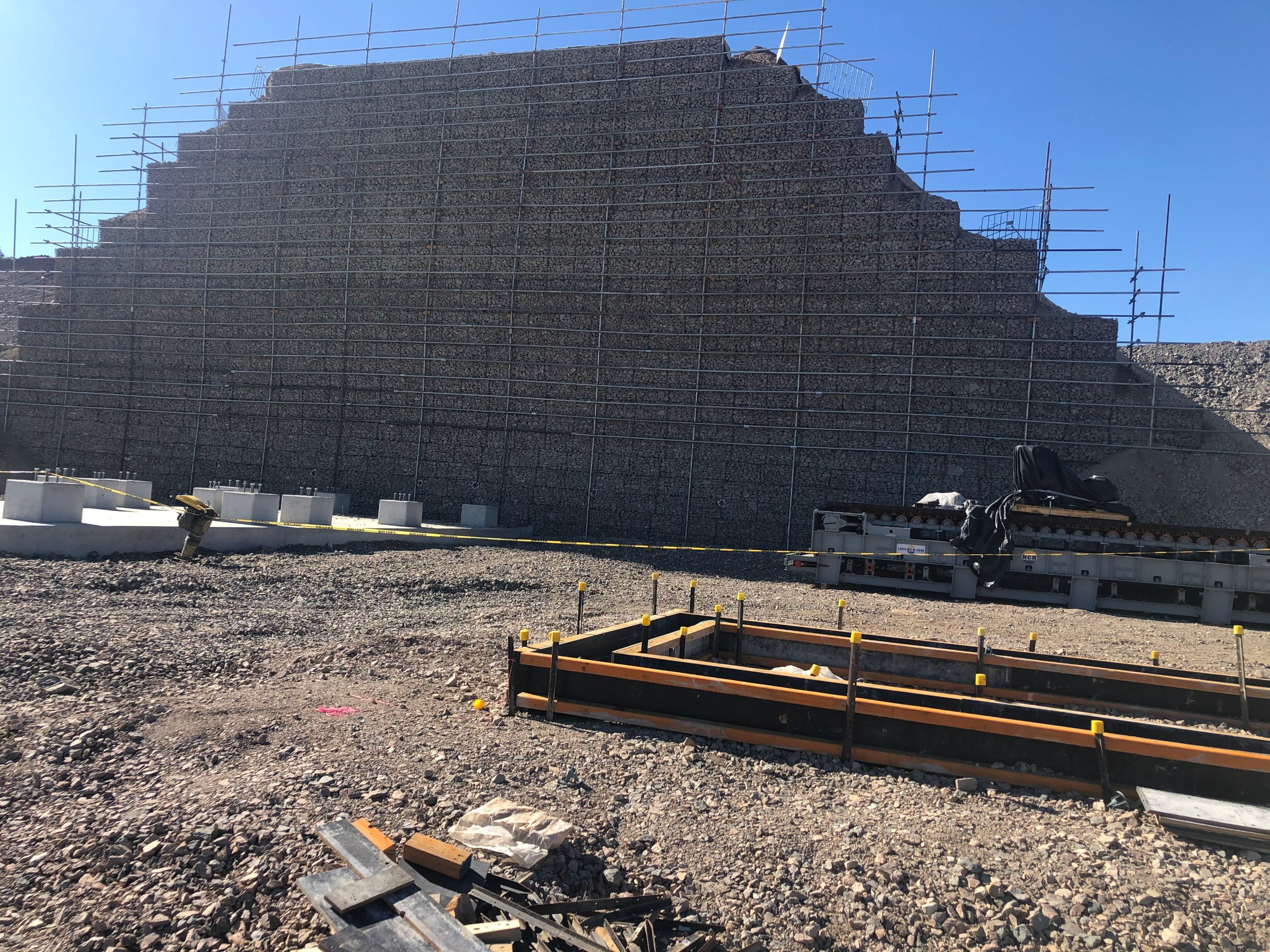 Massive gabion retaining wall aerial view with red earth and bushland